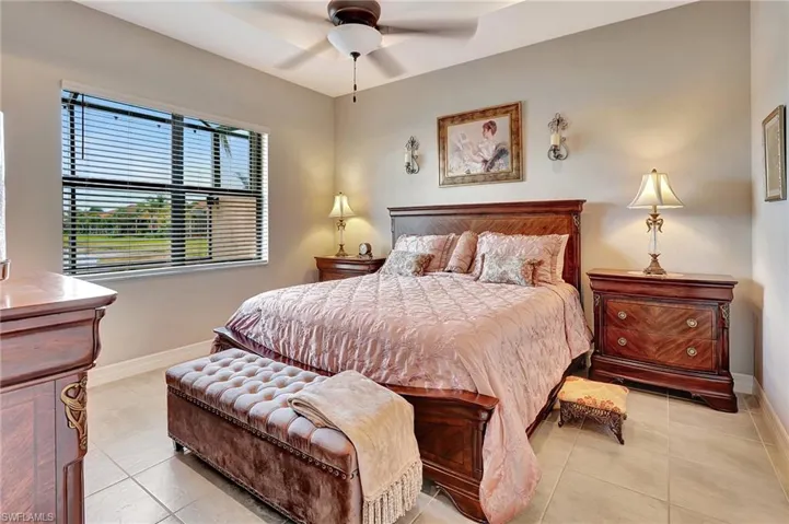 Bedroom with light tile patterned flooring, baseboards, and ceiling fan