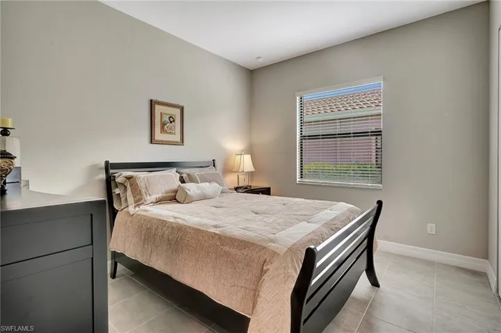 Bedroom with baseboards and light tile patterned floors