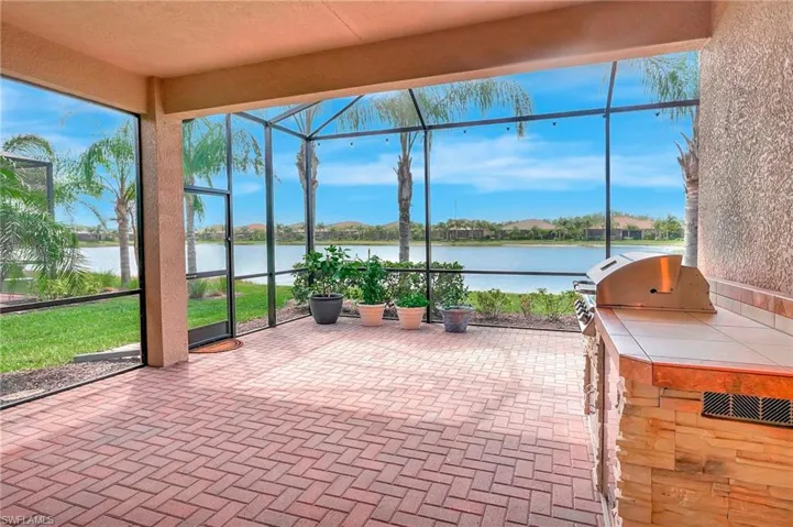 Unfurnished sunroom featuring area for grilling and a water view