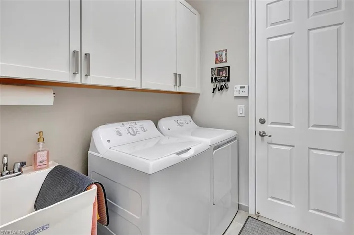Washroom with cabinet space, a sink, and washer and dryer