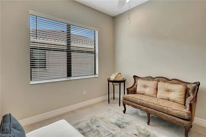 Living area featuring tile patterned flooring, baseboards, and ceiling fan