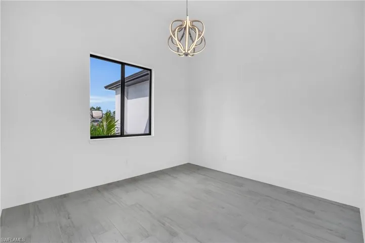 Unfurnished room with a chandelier and wood finished floors