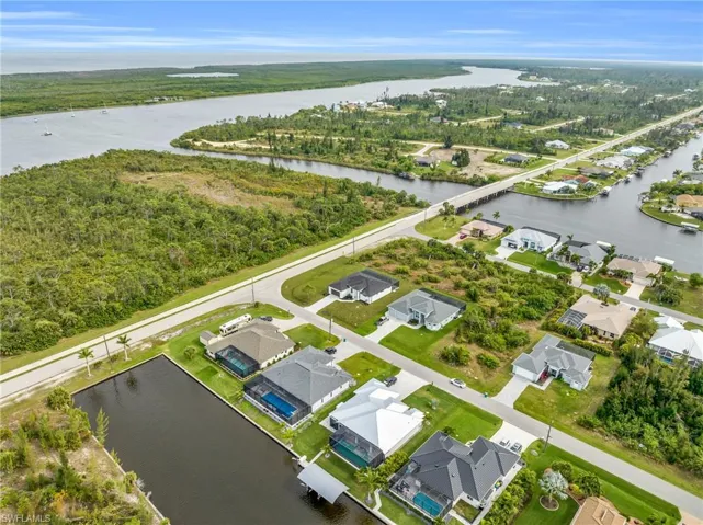 Aerial perspective of suburban area featuring a heavily wooded area and a large body of water
