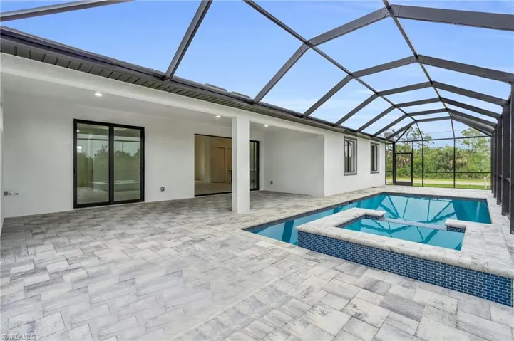 View of pool featuring a lanai, a patio area, and a pool with connected hot tub