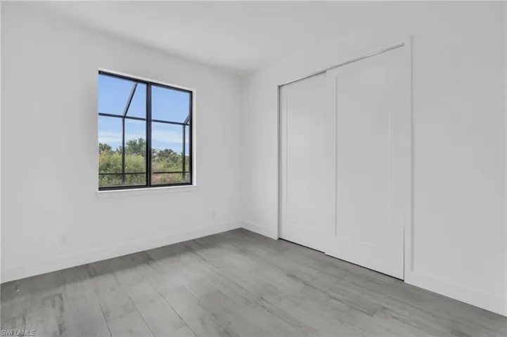 Unfurnished bedroom featuring wood finished floors and a closet