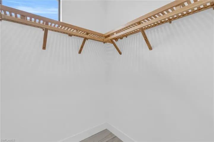 Walk in closet with light wood-style flooring