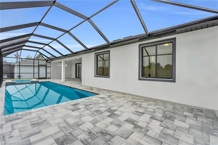 View of pool with a lanai, a patio area, and a pool with connected hot tub