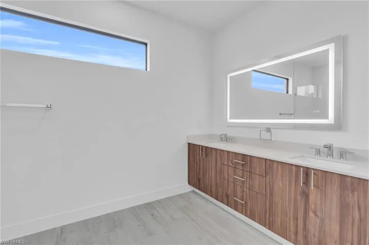 Full bath featuring double vanity and wood finished floors