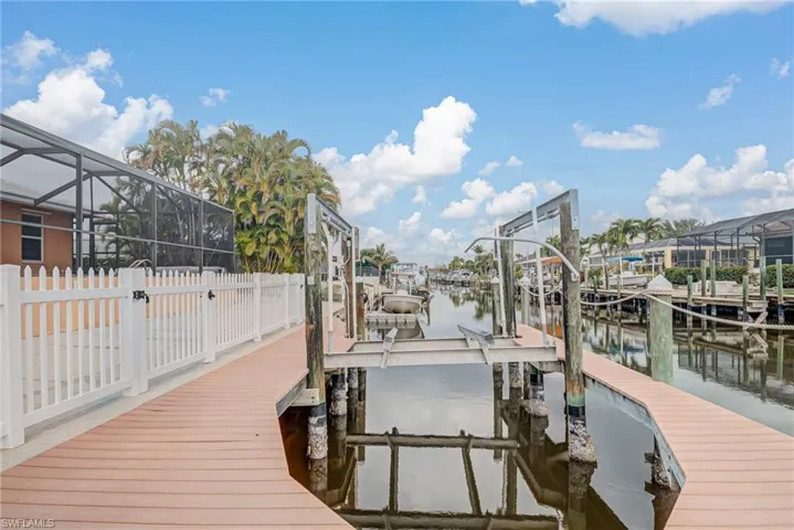 Dock area featuring a lanai, a water view, and boat lift