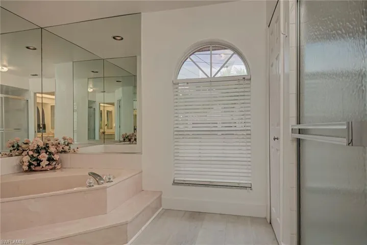 Bathroom with a shower stall, a bath, and recessed lighting