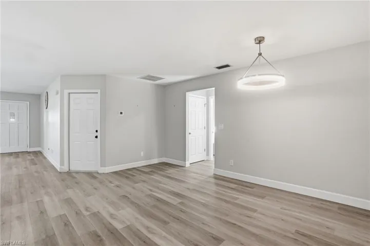 Spare room featuring baseboards and light wood-type flooring