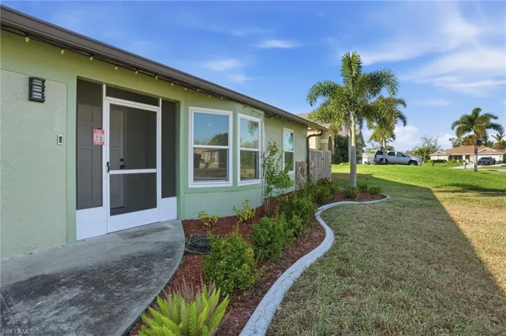 View of side of property featuring stucco siding and a yard