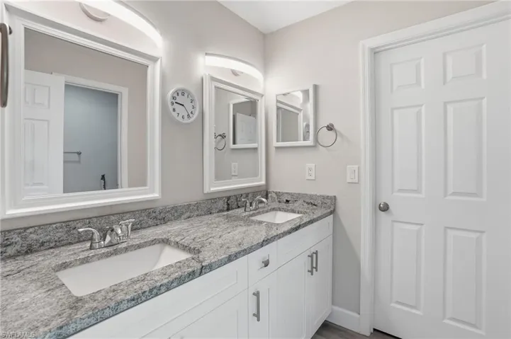 Full bath with double vanity and baseboards