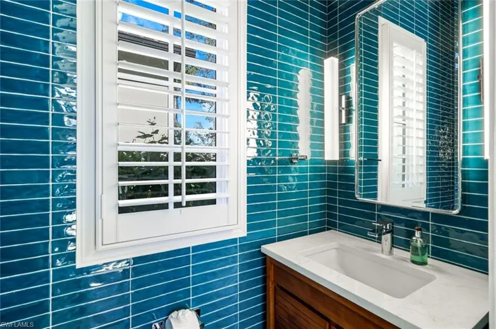 Bathroom with vanity and tile walls