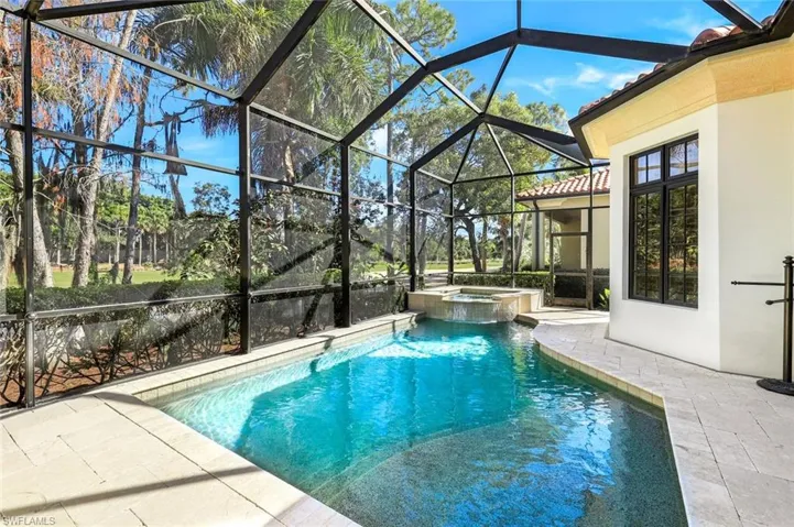Relaxing pool / spa with a sunroom, a patio area, and glass enclosure