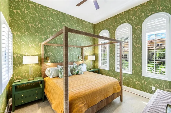 Carpeted bedroom with wallpapered walls and ceiling fan