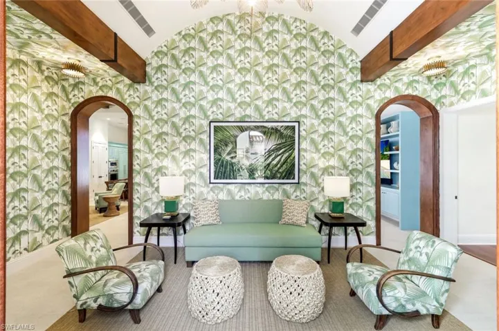 Living area with arched walkways, a barrel ceiling, and beam ceiling