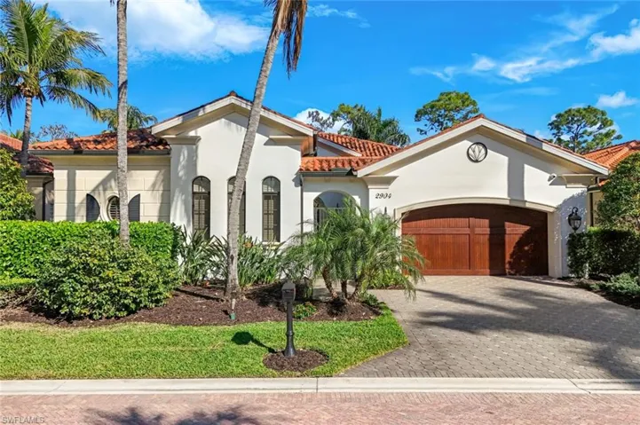 Mediterranean / spanish-style home with a tiled roof, stucco siding, decorative driveway, and an attached garage