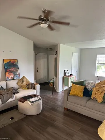 Spacious interior featuring wood-finish flooring, light-colored walls, and a ceiling fan with integrated lighting