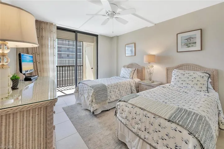 Tiled bedroom with access to outside, expansive windows, and a ceiling fan