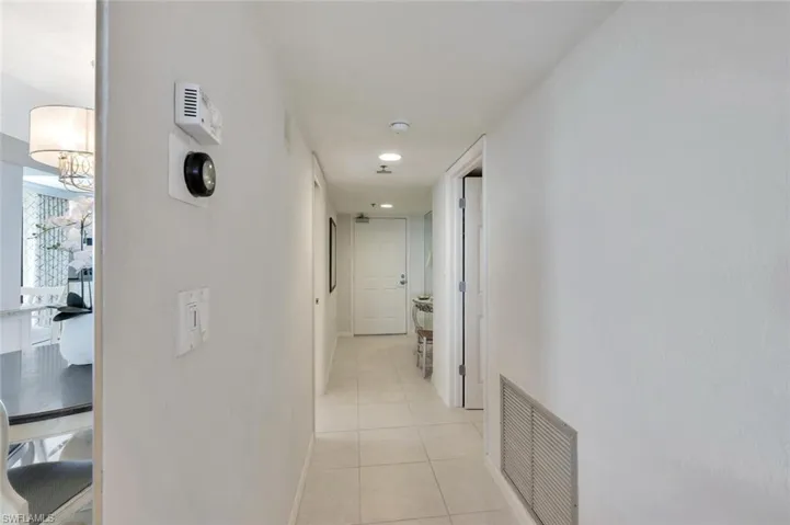Hallway featuring light tile patterned flooring and baseboards