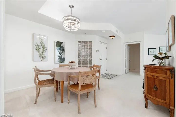 Dining area featuring light carpet and a notable chandelier