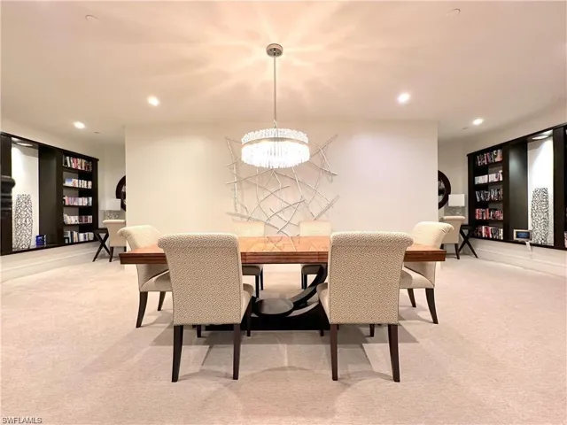 Dining area featuring a notable chandelier and light colored carpet