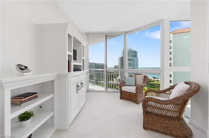 Sitting room featuring light colored carpet and a water view