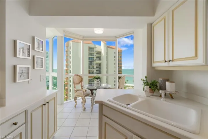 Kitchen featuring sink, a water view, a healthy amount of sunlight, and light tile patterned floors