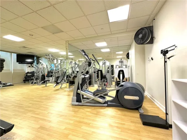 Exercise room featuring a paneled ceiling and light wood-type flooring