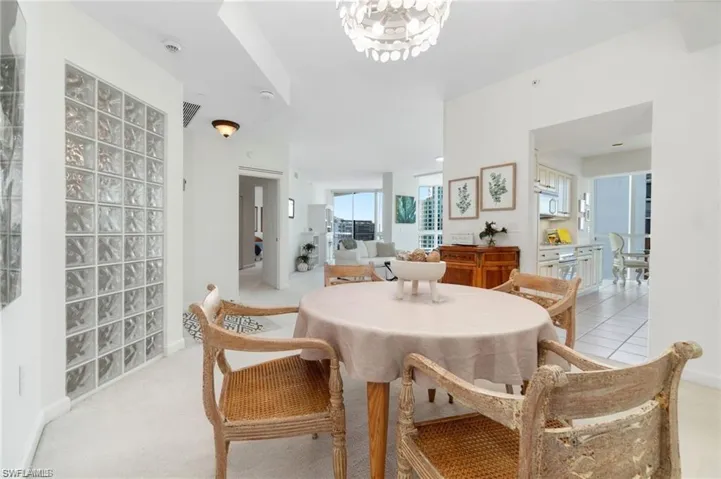 Dining room featuring light carpet and a notable chandelier