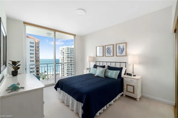 Carpeted bedroom with access to outside and a water view
