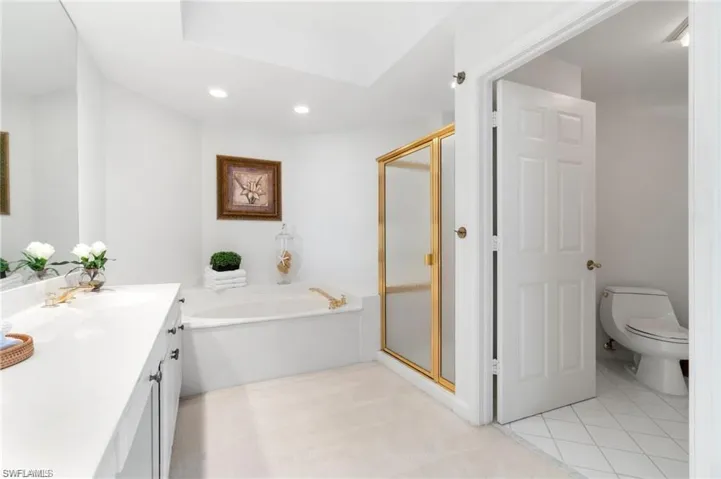 Full bathroom featuring vanity, toilet, separate shower and tub, and tile patterned flooring