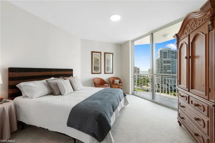 Carpeted bedroom with floor to ceiling windows and access to exterior