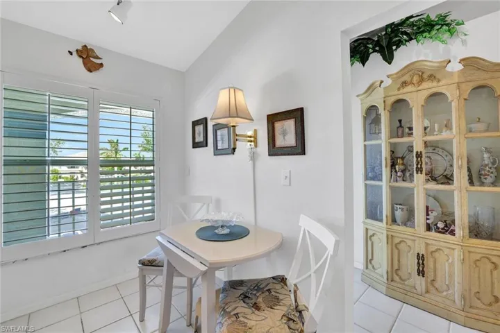 Tiled dining space featuring vaulted ceiling