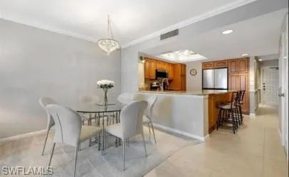 Dining area with crown molding and recessed lighting