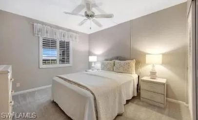 Bedroom with light colored carpet and a ceiling fan