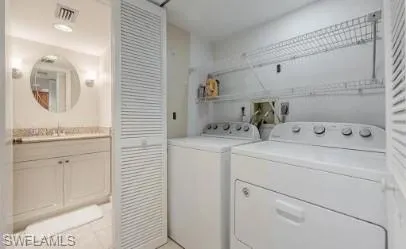 Laundry area featuring washing machine and clothes dryer and light tile patterned flooring