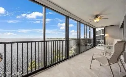 Sunroom / solarium featuring floor to ceiling windows and a water view