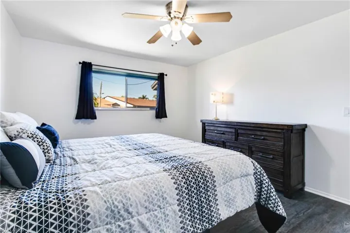 Bedroom with ceiling fan and dark wood-style floors
