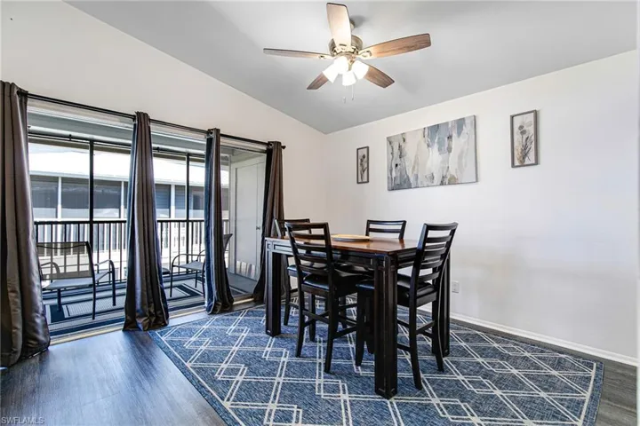 Dining room featuring lofted ceiling, dark wood-style flooring, and a ceiling fan