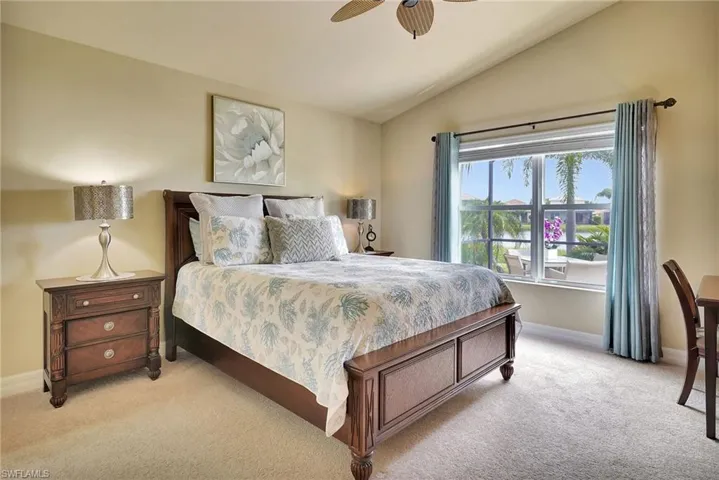 Carpeted bedroom featuring lofted ceiling and ceiling fan