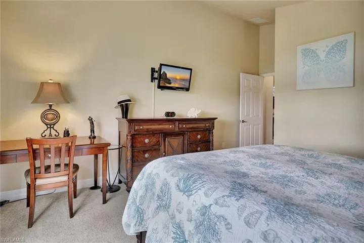Bedroom with a towering ceiling and light colored carpet