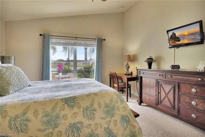 Bedroom with lofted ceiling and light colored carpet
