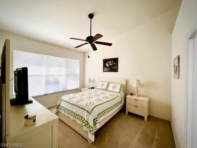 Bedroom featuring ceiling fan, carpet, and vaulted ceiling