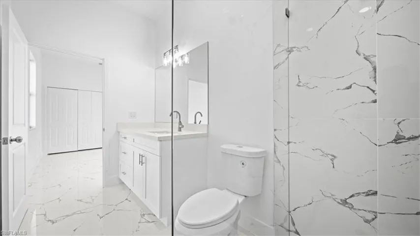 Bathroom featuring vanity and light marble finish floors