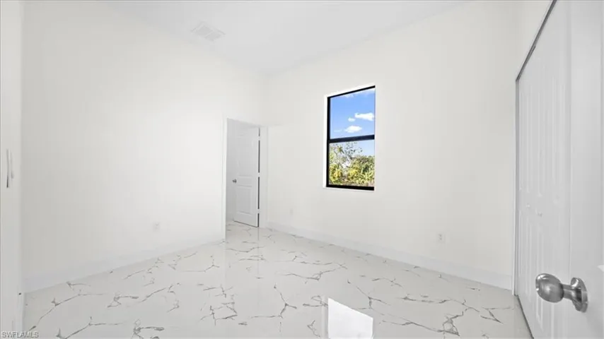 Unfurnished bedroom with light marble finish flooring and a closet