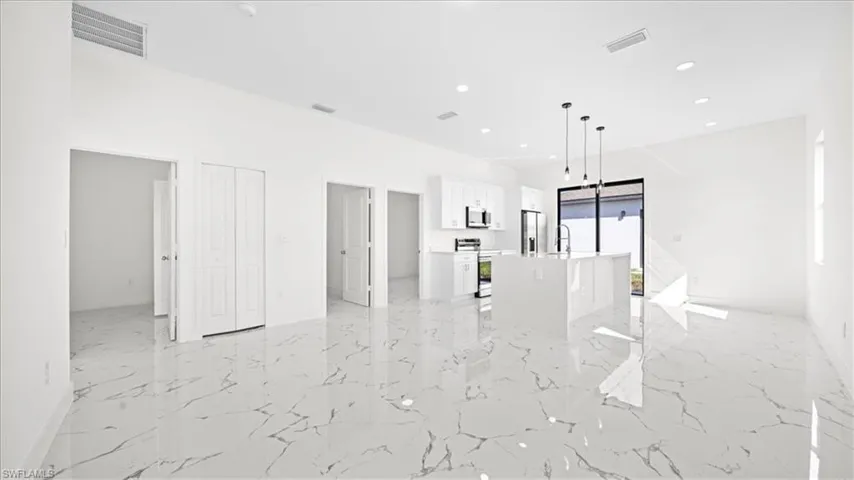 Unfurnished living room featuring recessed lighting and light marble finish flooring