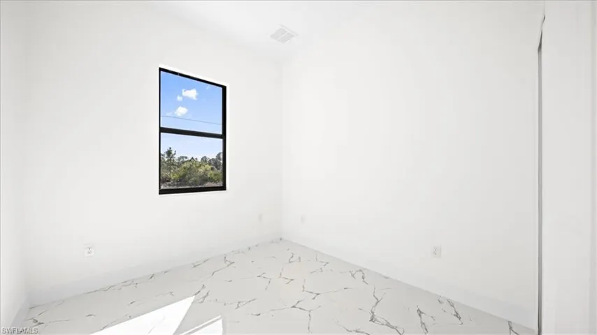 Empty room featuring baseboards and light marble finish floors