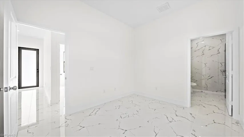 Spare room with light marble finish floors and baseboards